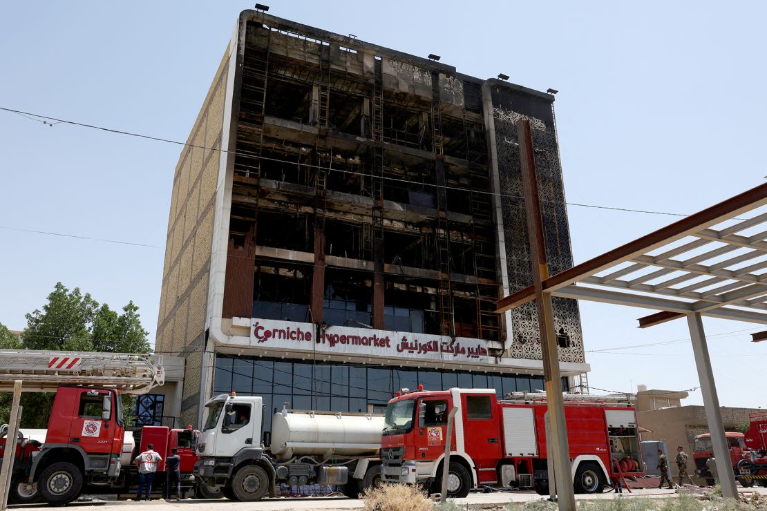 Fire trucks stand next to the wreckage of a shopping center on July 17, 2025, after a massive overnight fire <a href=