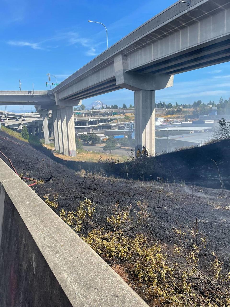 Crews work on putting out a brush fire near the Sprague exit of State Route 16 on July 19, 2025.