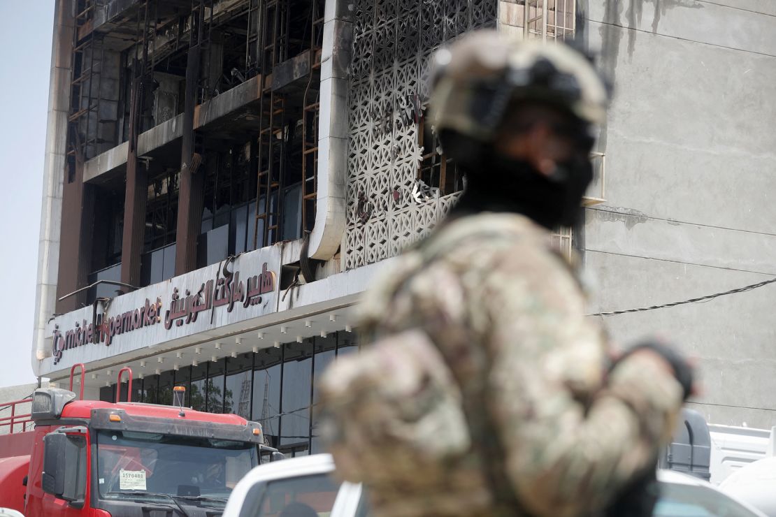 A member of the Iraqi security forces in front of a damaged shopping mall on July 17, 2025, after a fire tore through the newly opened building in the eastern Iraqi city of Kut overnight.